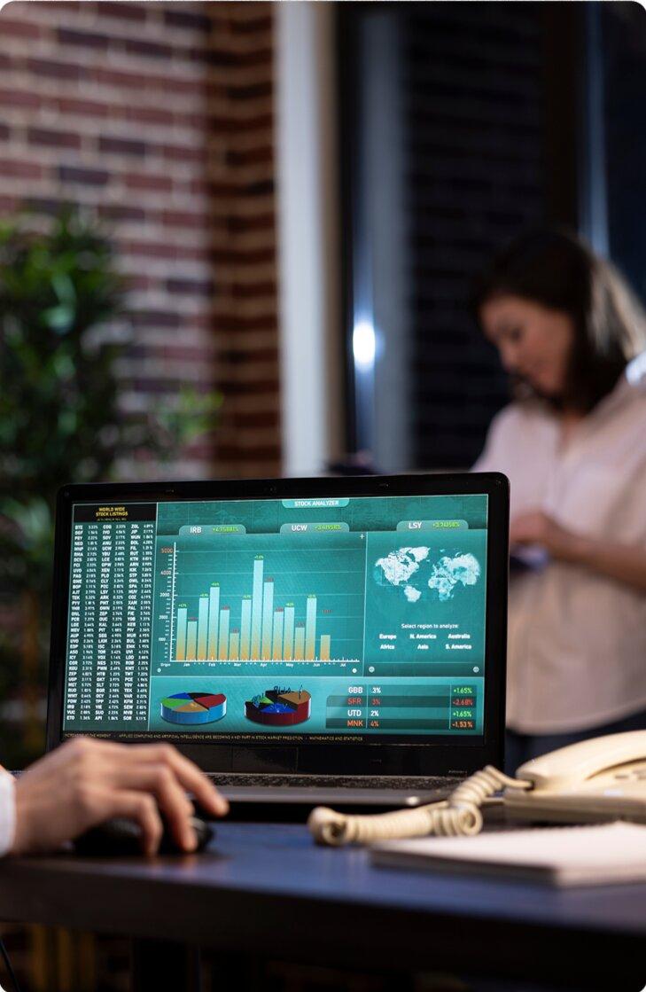 Analyst reviewing a cloud data dashboard on a laptop in a modern office